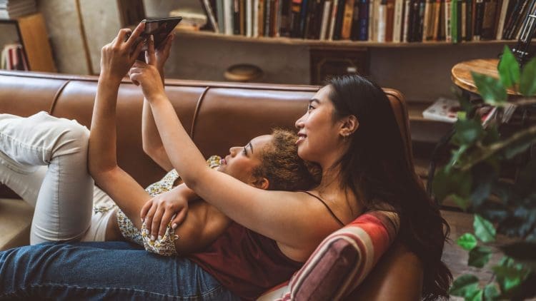 Two women in their apartment looking at digital tablet