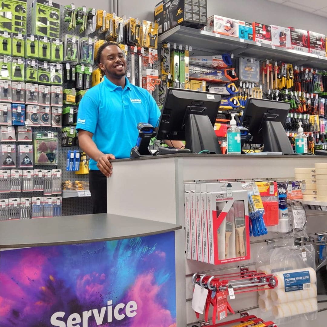 Member of staff stood as a service desk in Leyland store