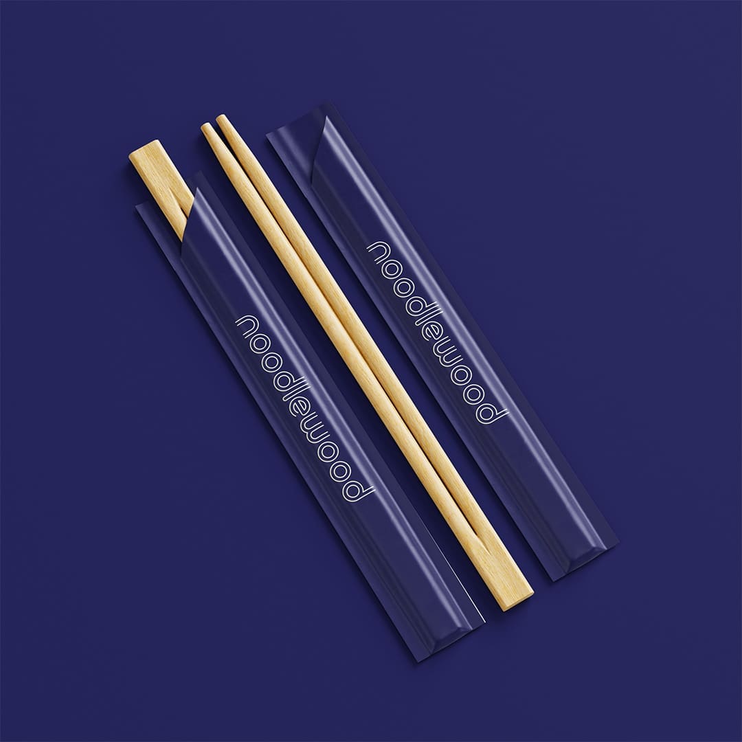 Chopsticks in a blue branded sleeve containing the noodlewood logo.