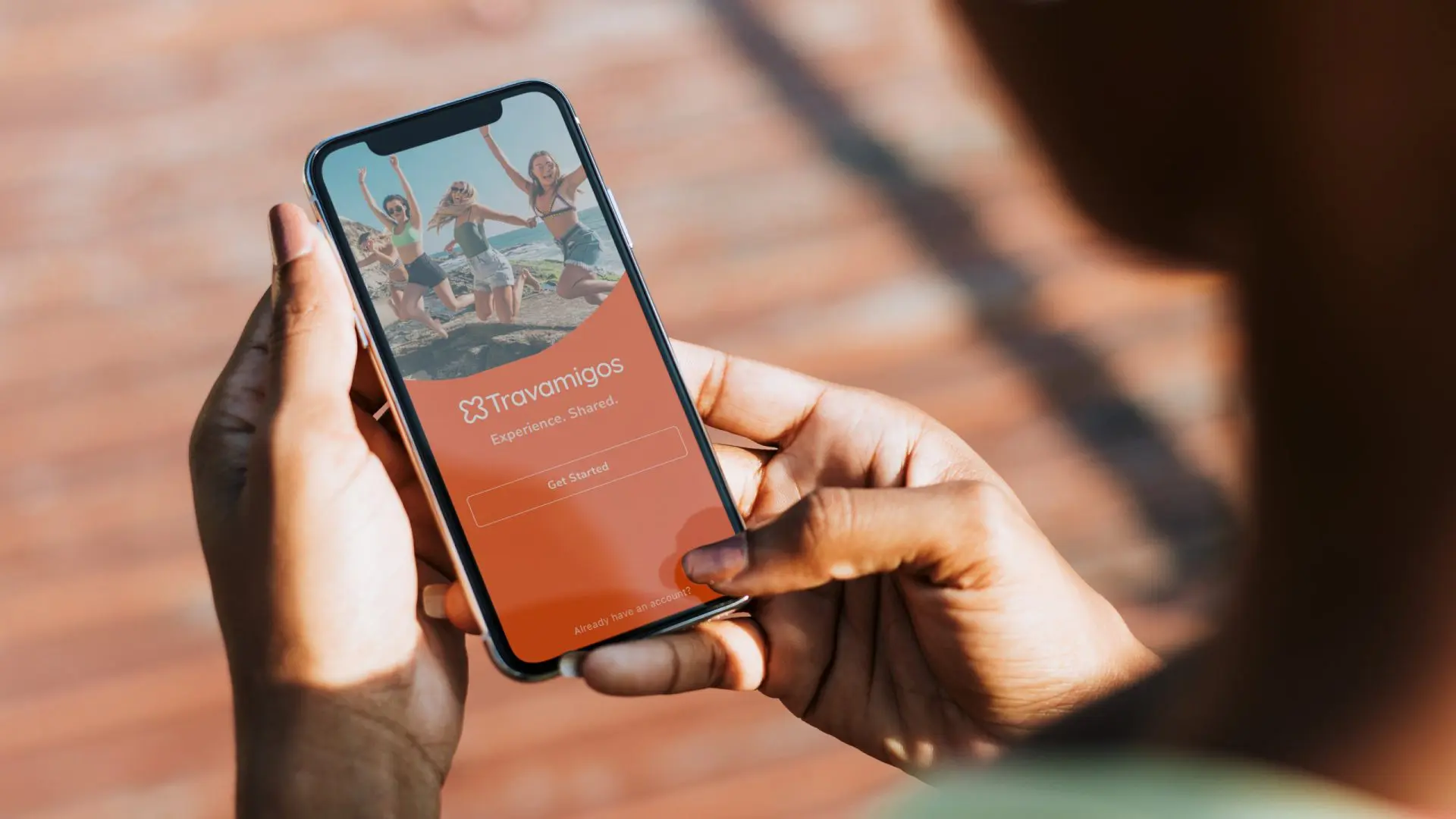 Hands holding a mobile phone showing Travamigos